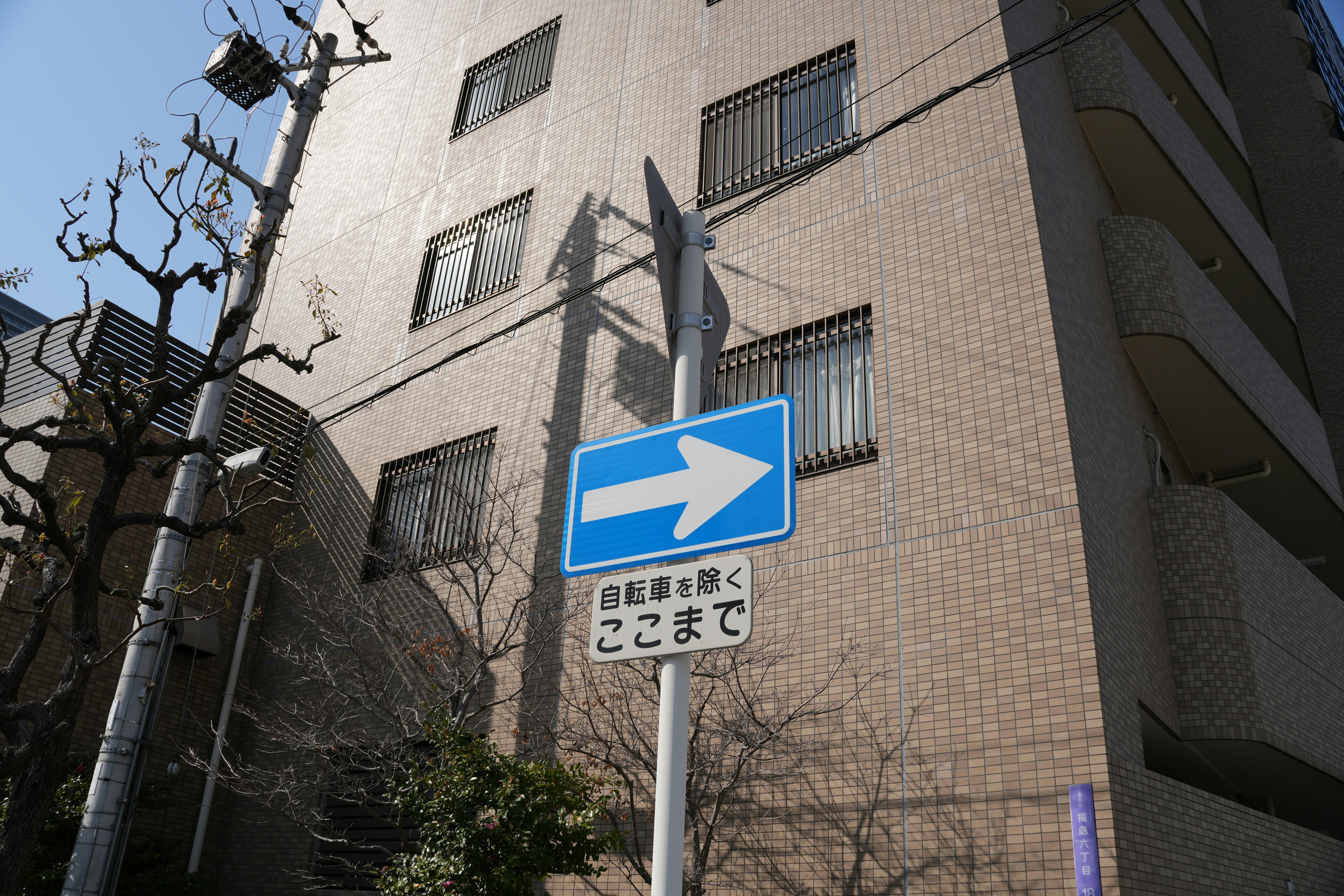 a blue street sign sitting next to a tall building