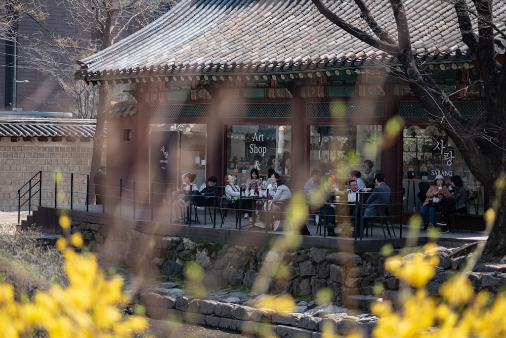 a group of people sitting at a table in front of a building