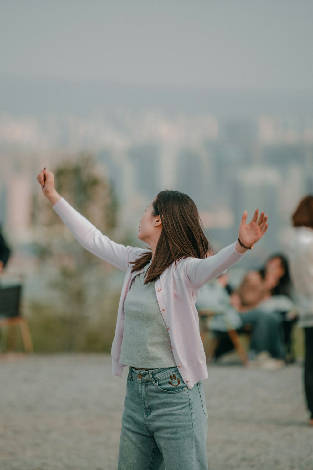 a woman standing in a field with her arms outstretched