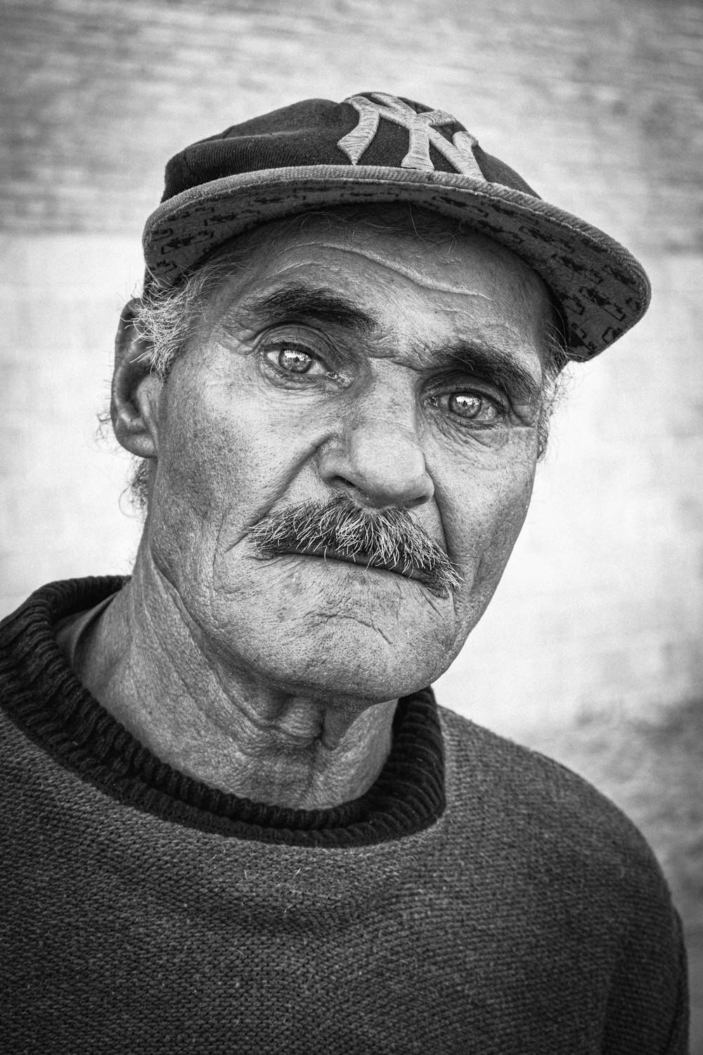 a black and white photo of a man wearing a hat