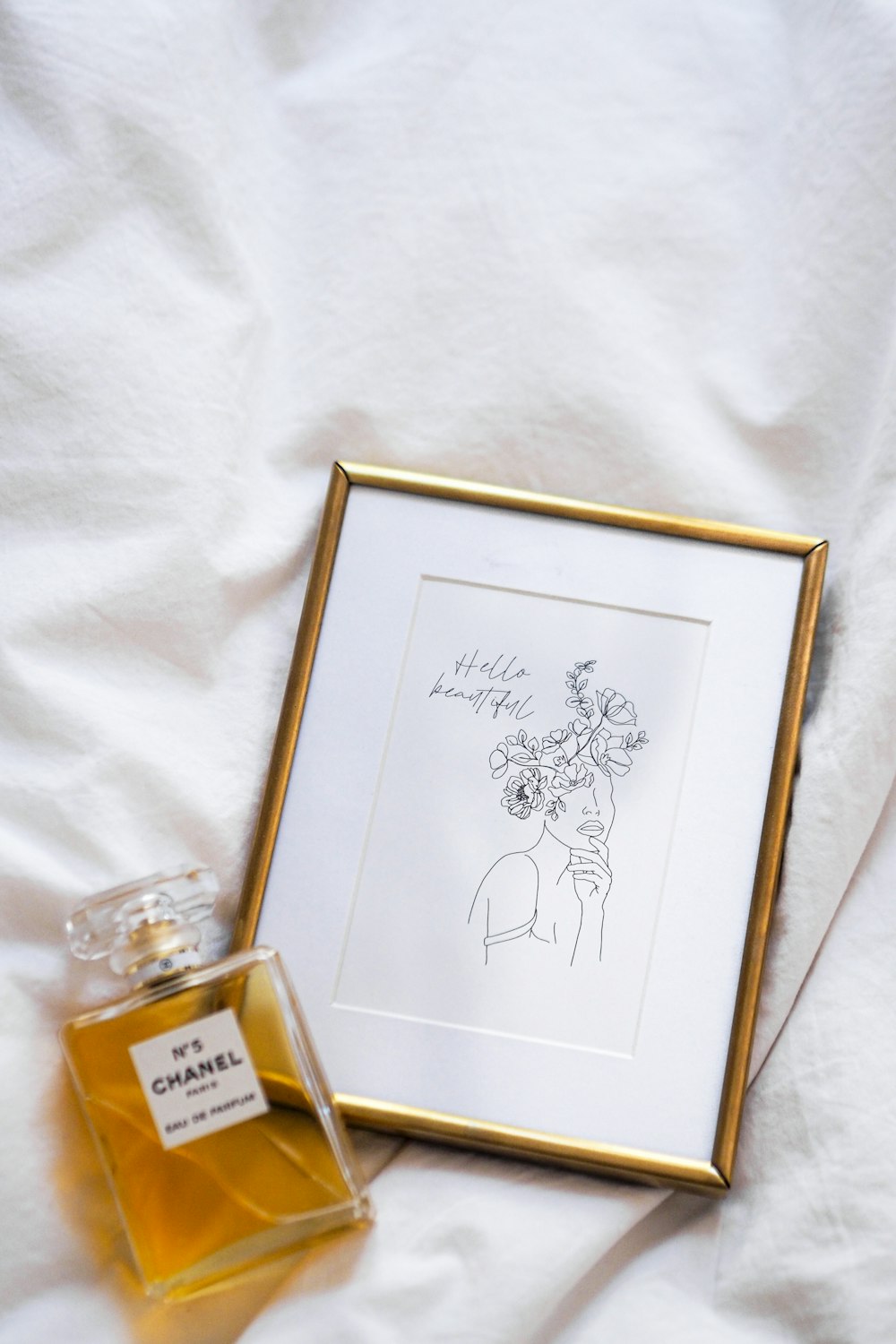 a bottle of perfume sitting next to a picture frame