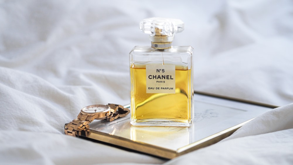 a bottle of perfume sitting on top of a bed