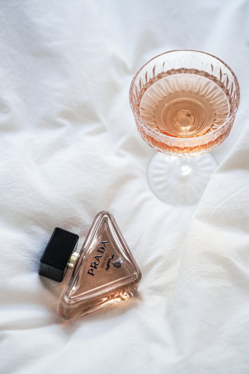 a bottle of perfume sitting next to a glass