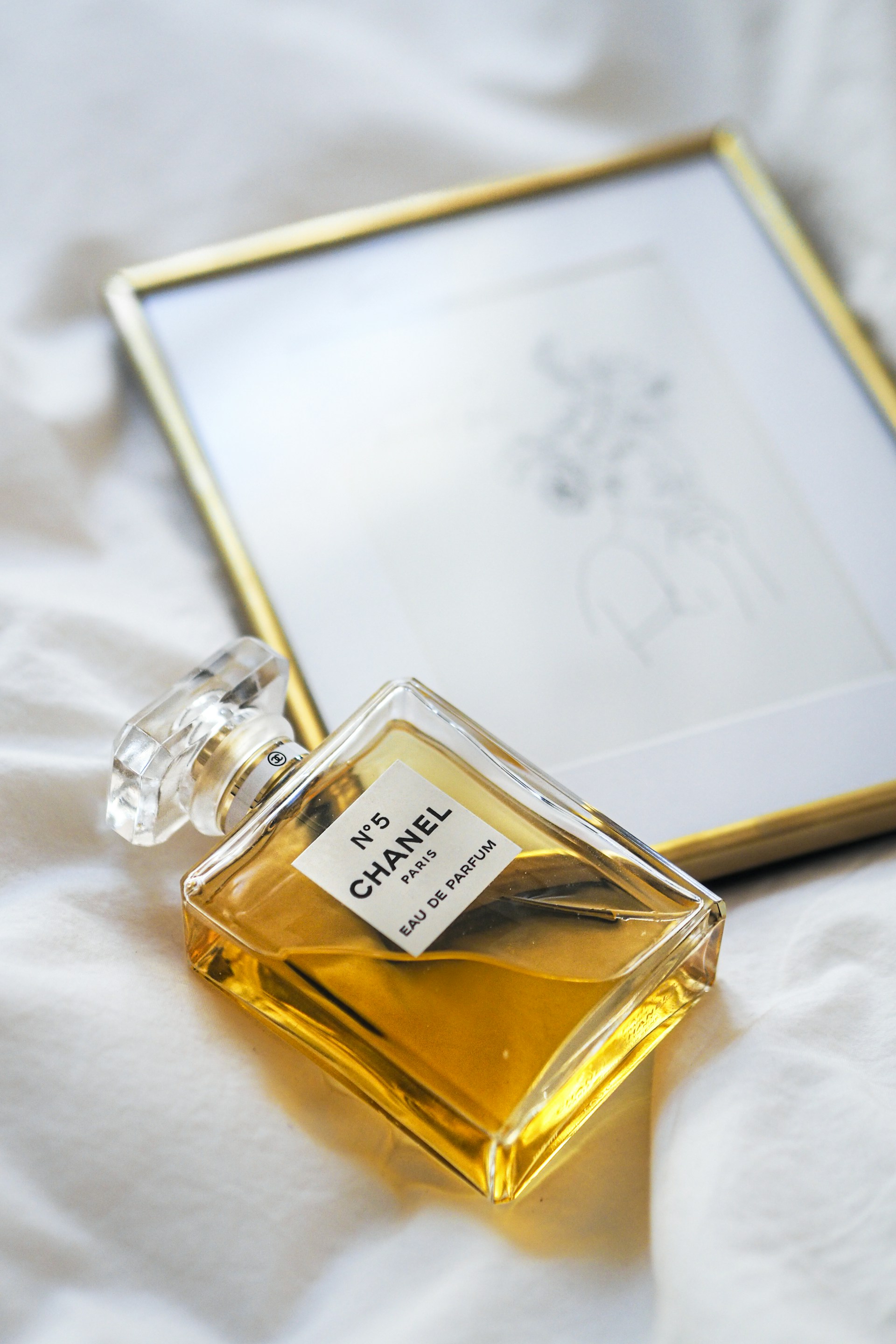 a bottle of perfume sitting on top of a bed