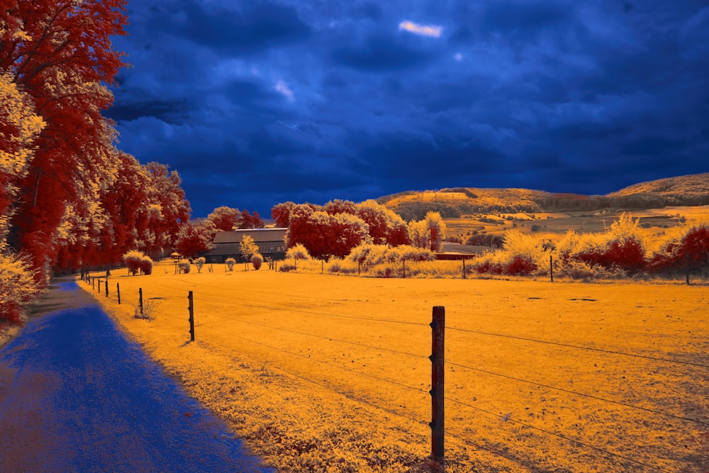 um campo com uma cerca e uma casa ao longe