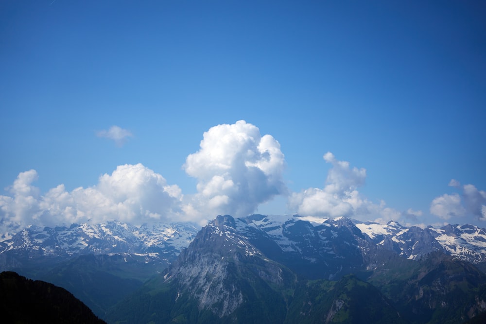 Una vista de una cadena montañosa con una nube en el cielo