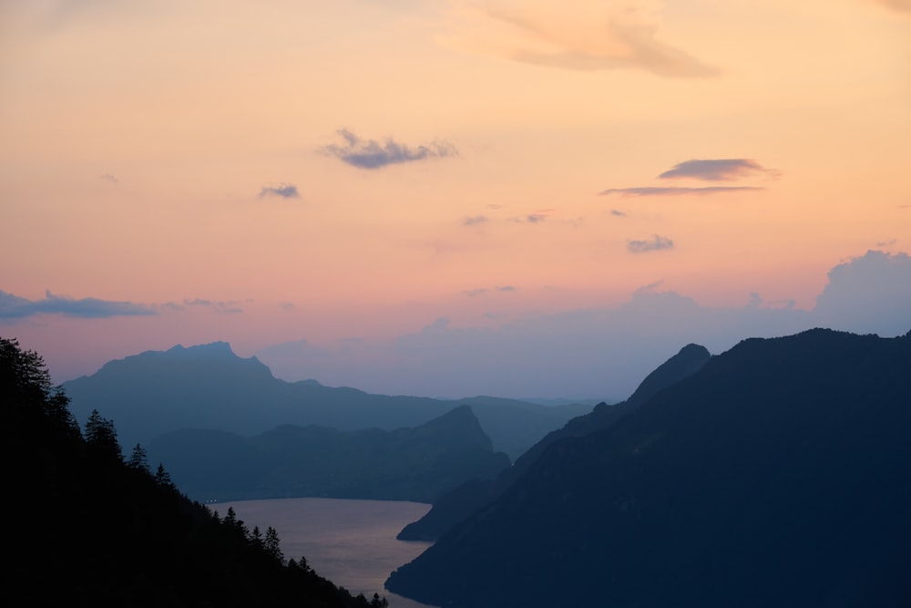 a view of a lake and mountains at sunset