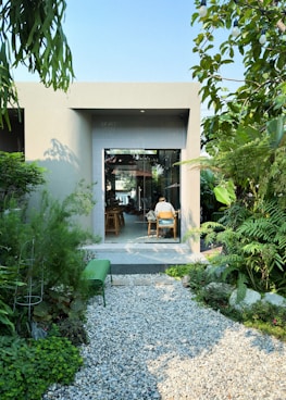 a person sitting at a table in a garden