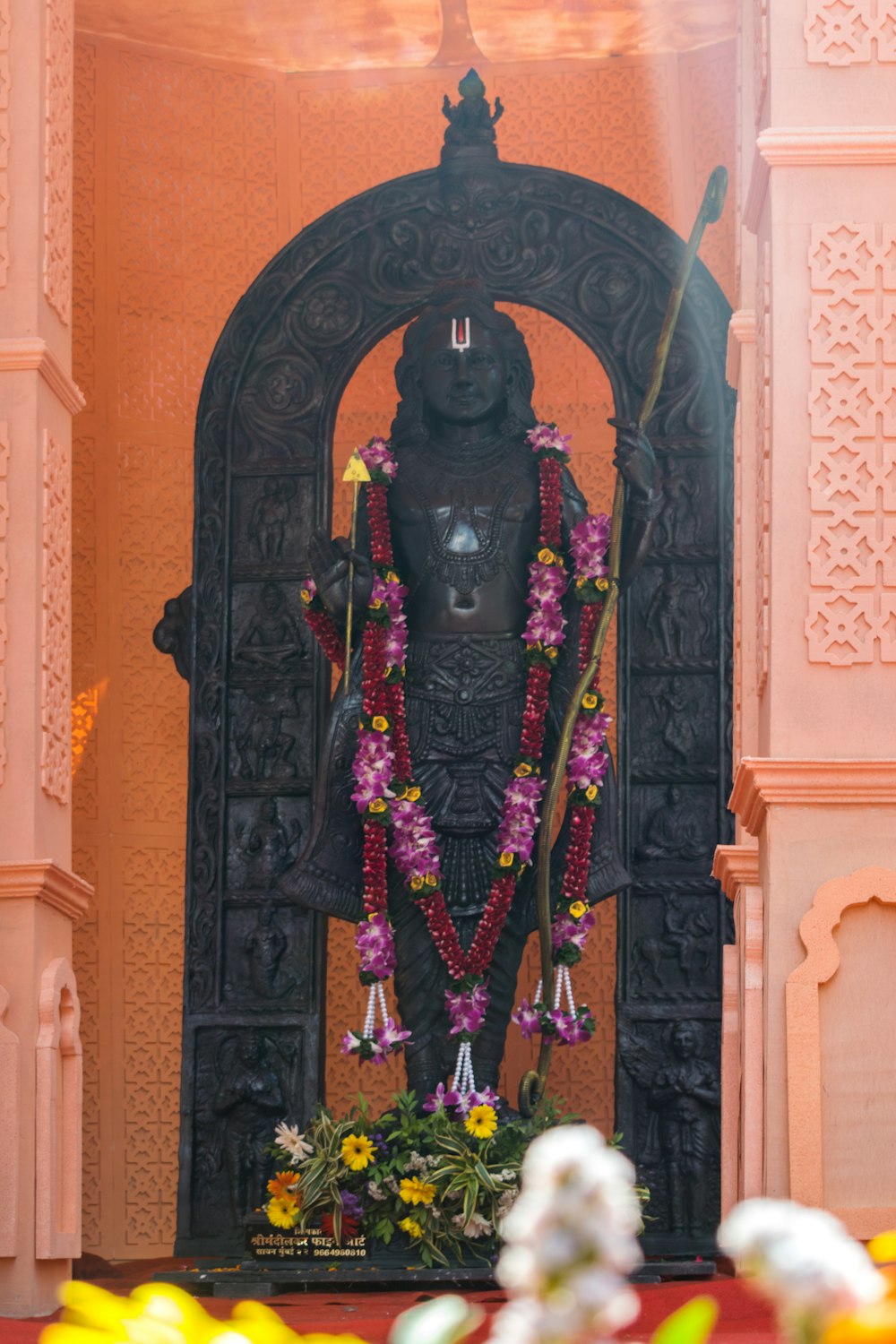 uma estátua de uma pessoa com flores ao seu redor