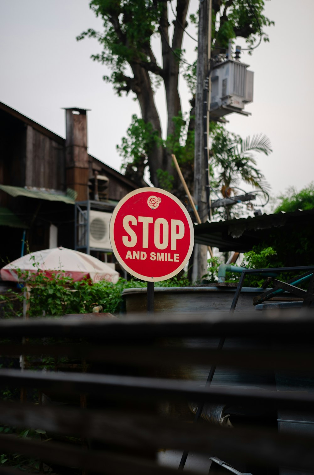 a stop and smile sign in front of a tree