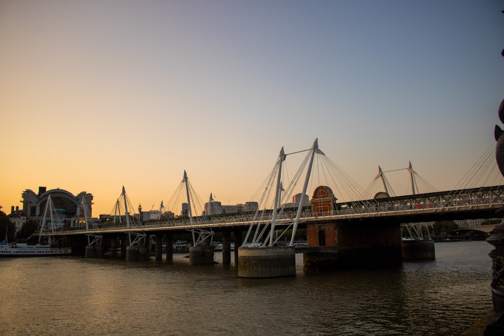 a bridge over a body of water with a city in the background