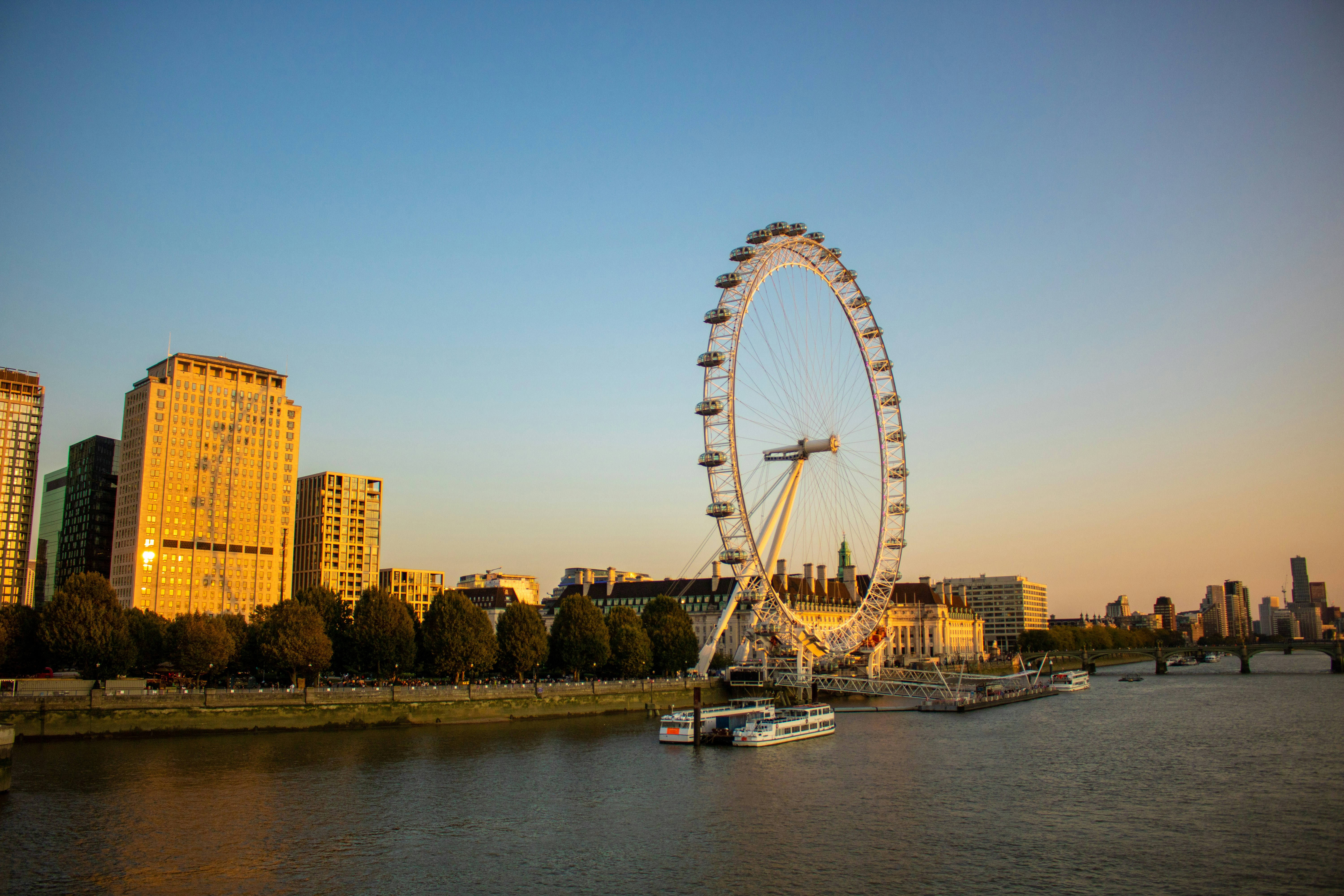 a large ferris wheel sitting next to a river