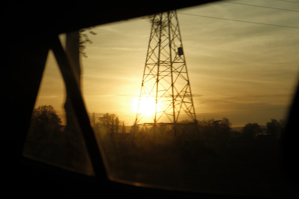 the sun is setting behind a power tower