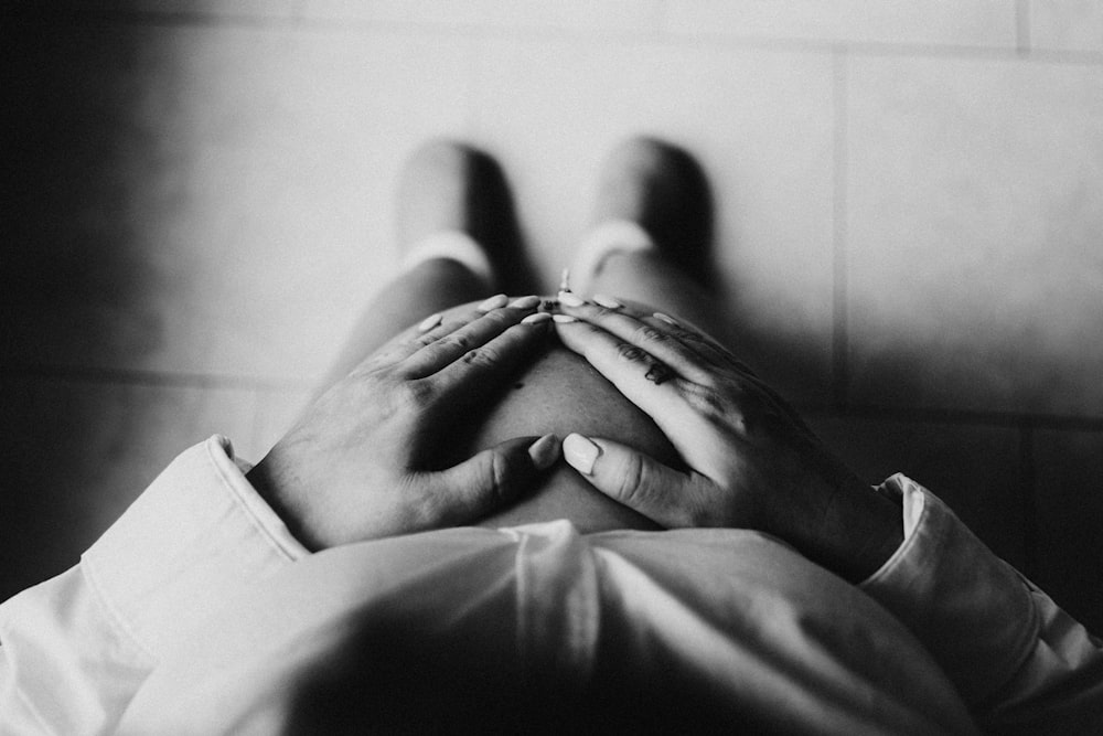 a black and white photo of a person holding their hands together