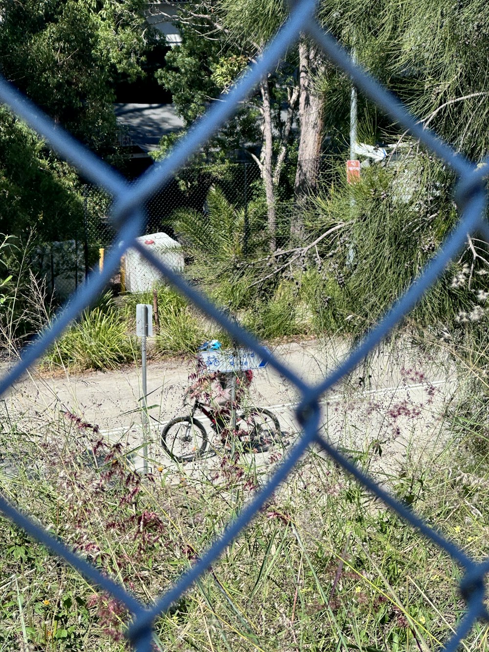 a bike parked in a field behind a fence