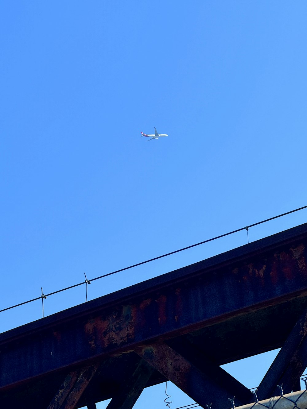 an airplane is flying over a bridge on a clear day