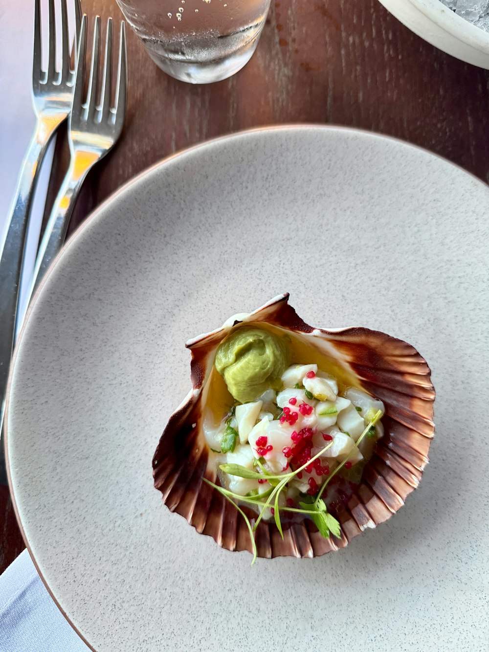 a white plate topped with a piece of food on top of a wooden table