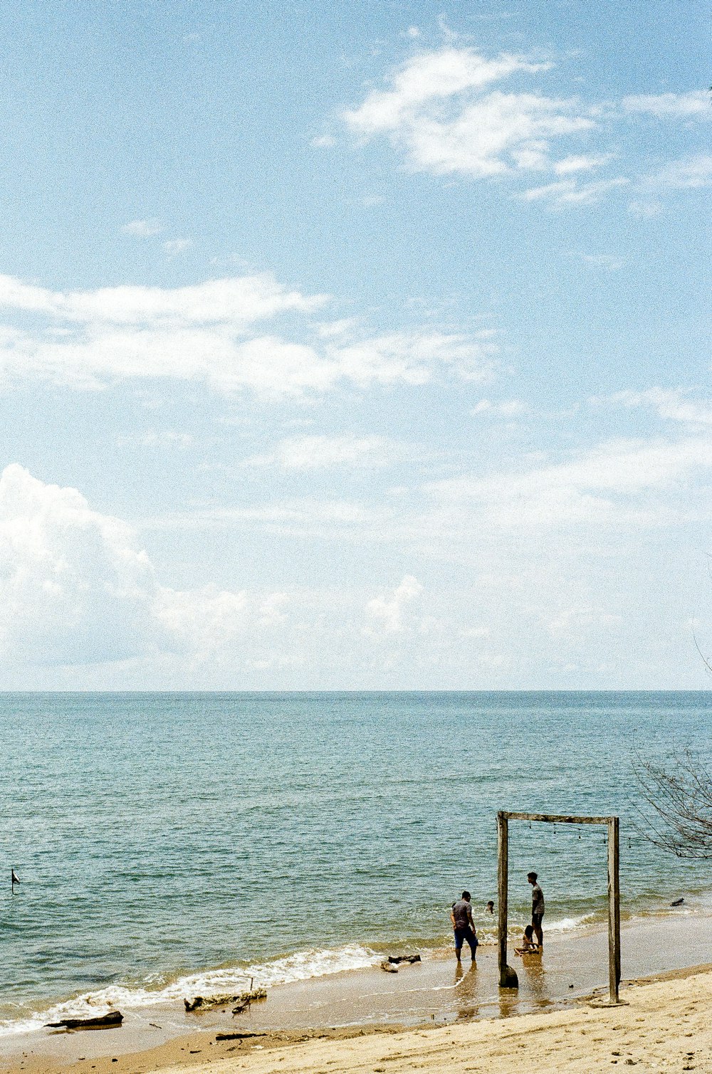 un gruppo di persone in piedi in cima a una spiaggia sabbiosa