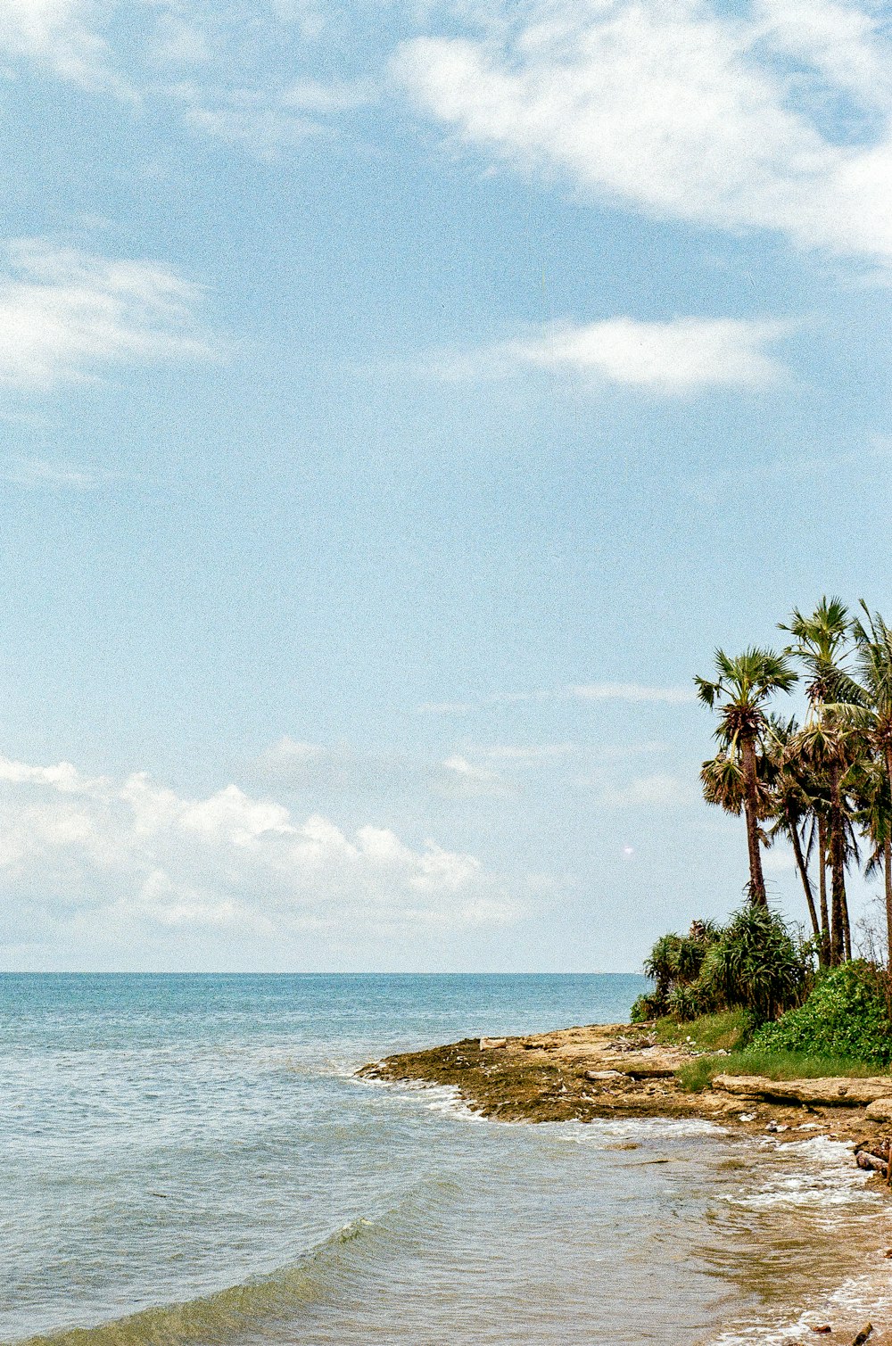 a man riding a surfboard on top of a sandy beach