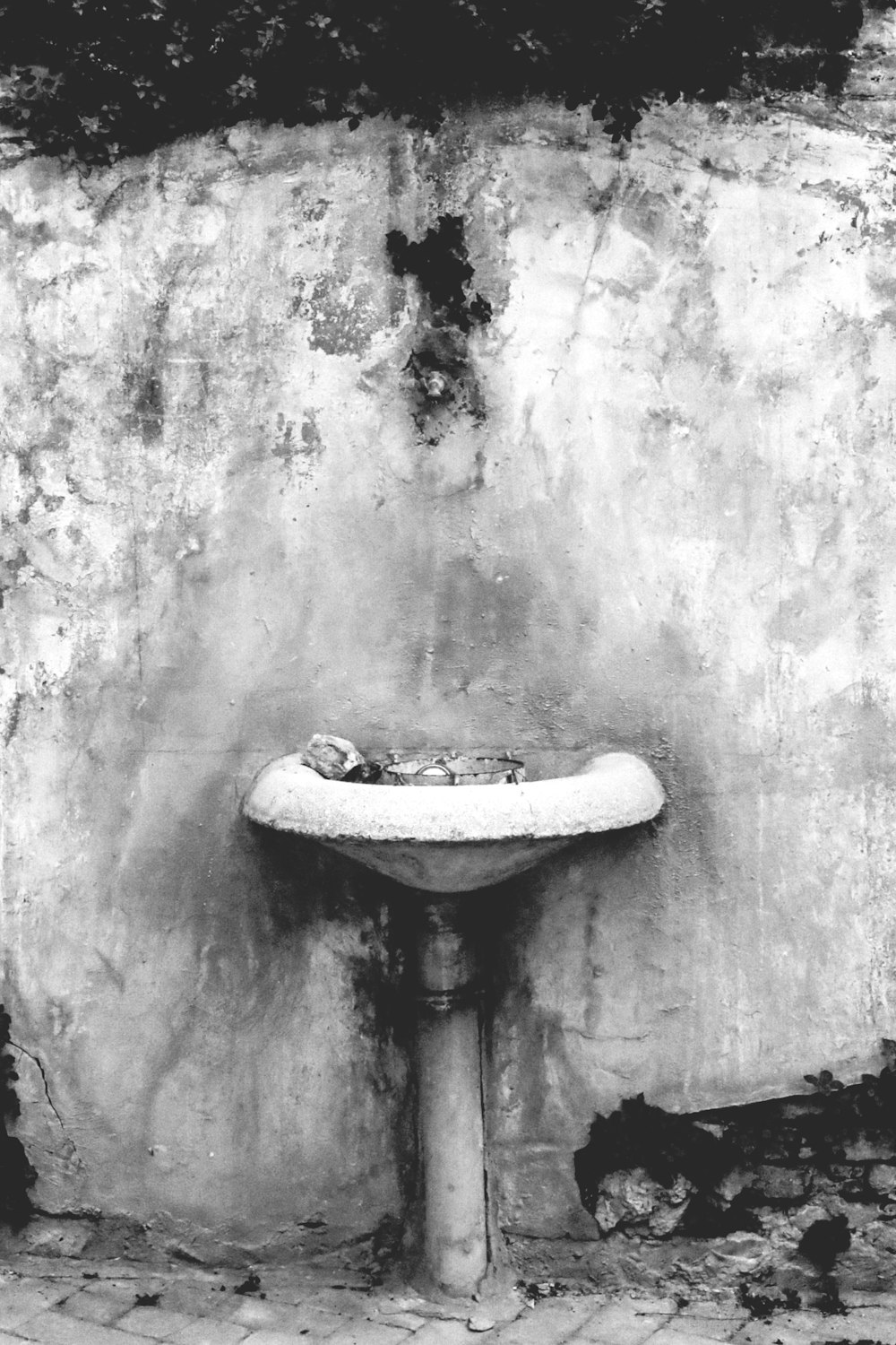 a stone sink in front of a wall