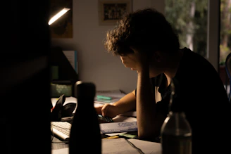 a man sitting at a desk working on a laptop computer