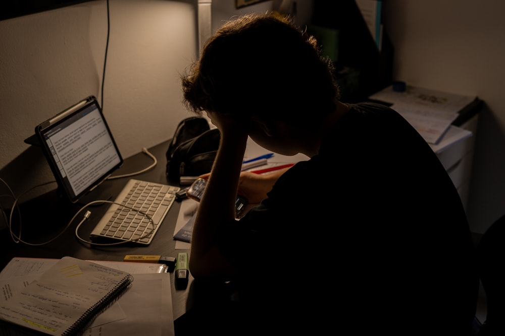 a person sitting in front of a laptop computer