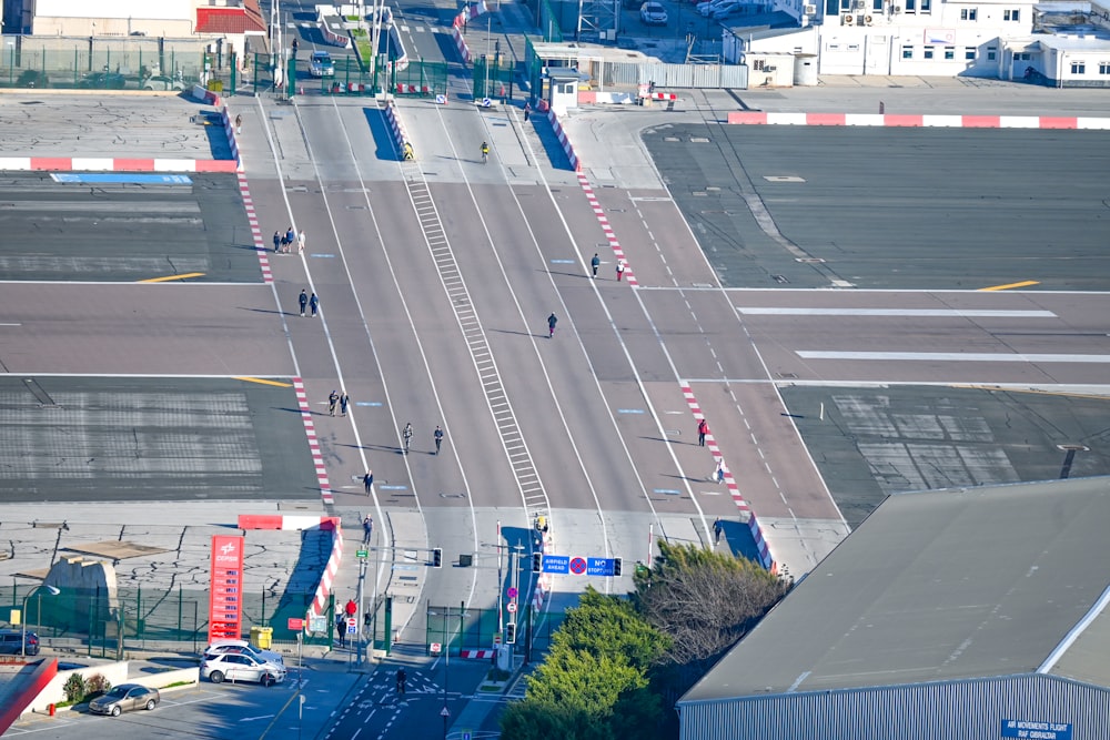 an aerial view of a city street with a train crossing