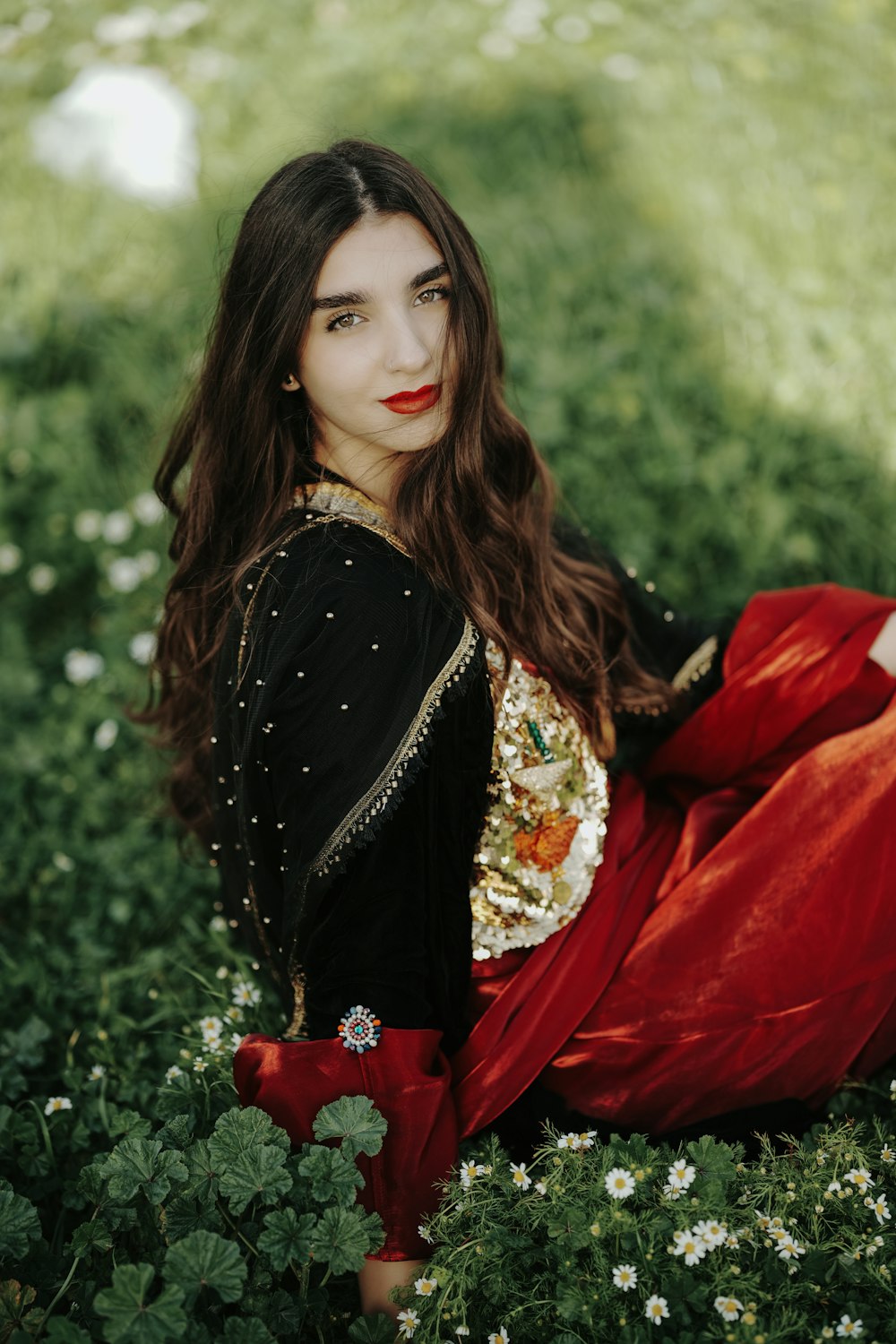 a woman in a red dress sitting in a field