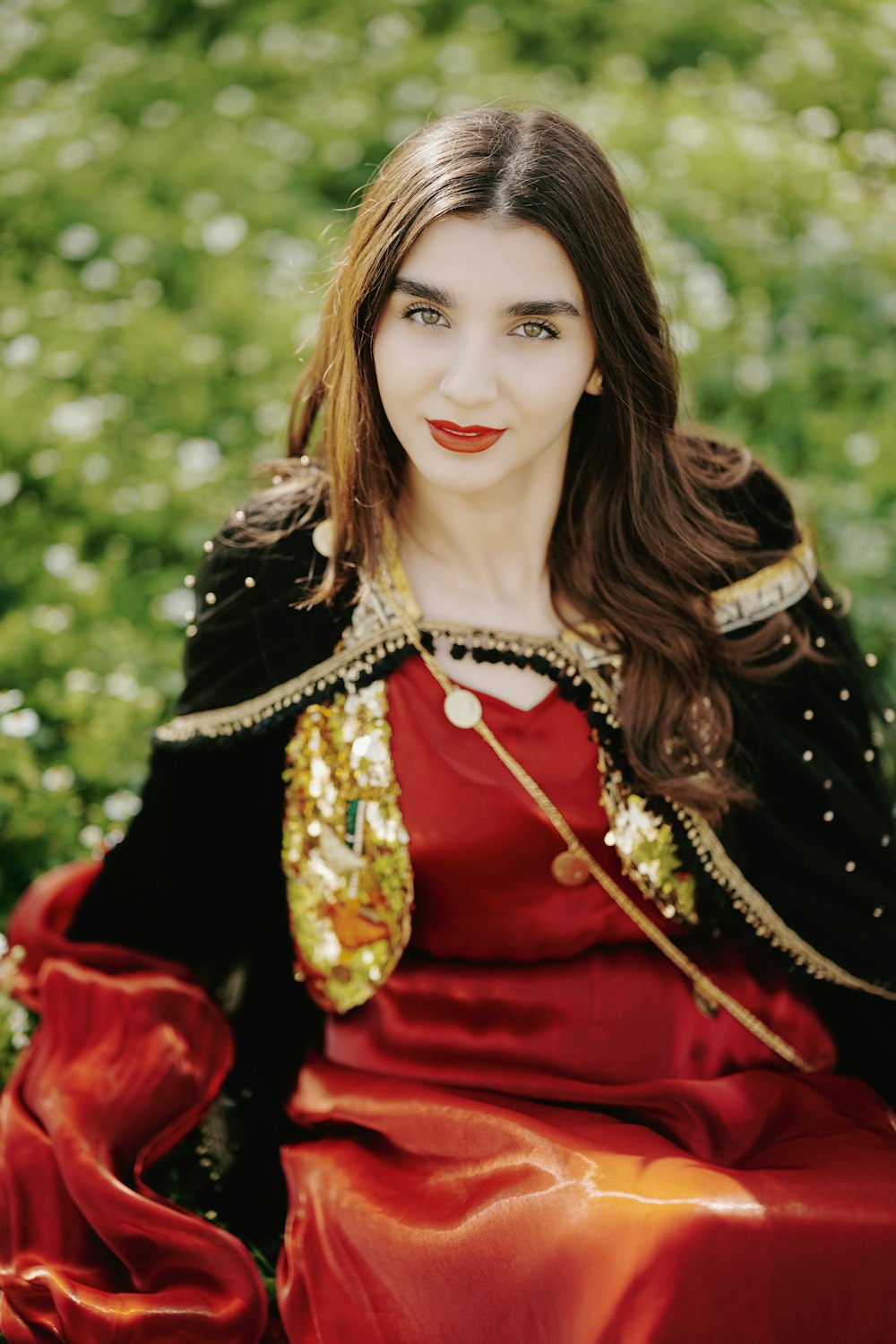 a woman in a red dress sitting in a field