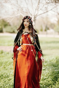 a woman in a red dress standing in a field