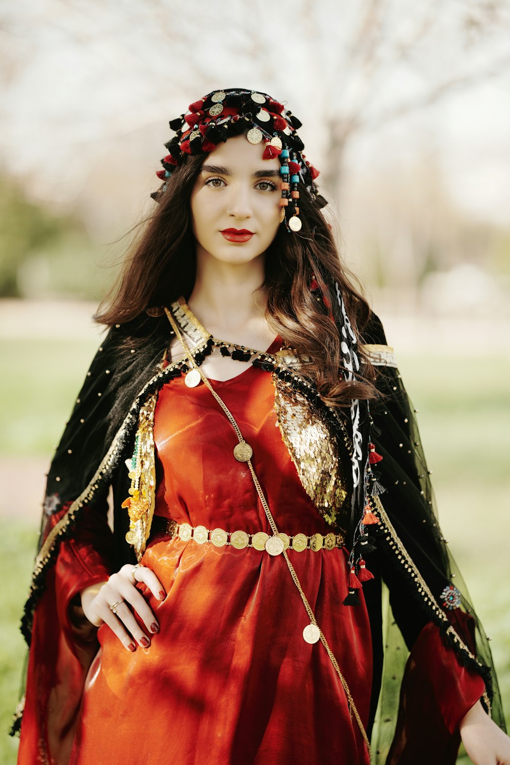 a woman wearing a red dress and a black cape