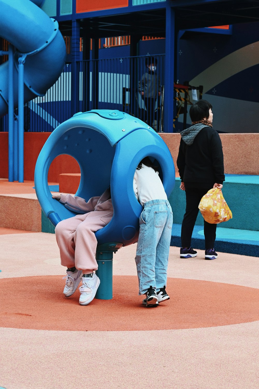 una mujer y un niño jugando en un patio de recreo