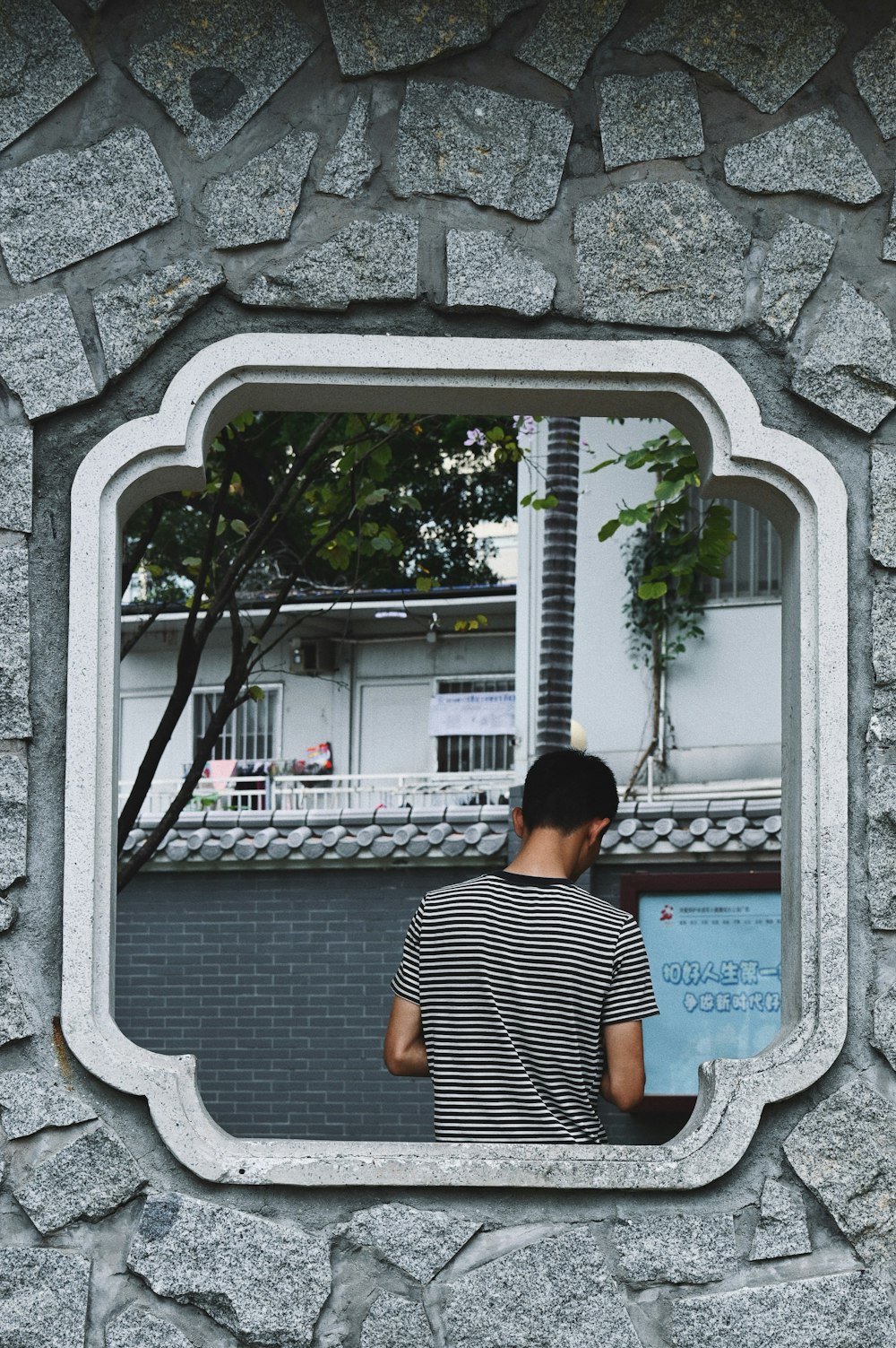 a man standing in front of a stone wall