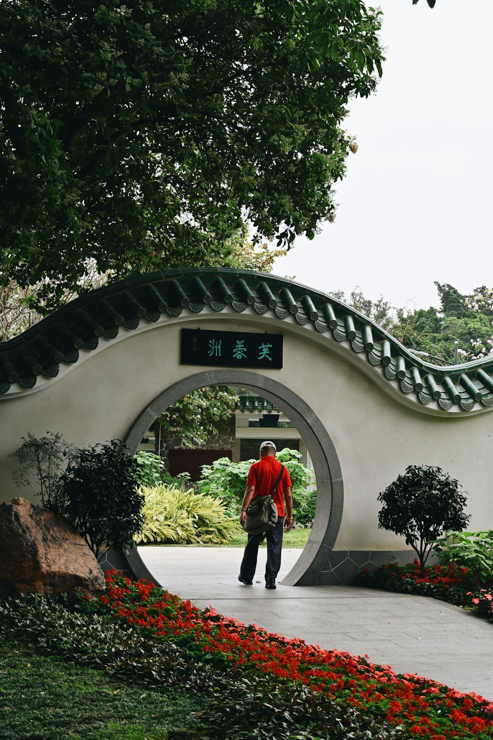 a man in a red shirt is walking through a tunnel