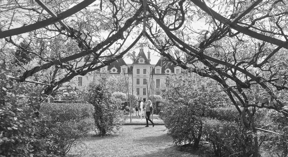 a black and white photo of people walking in front of a building