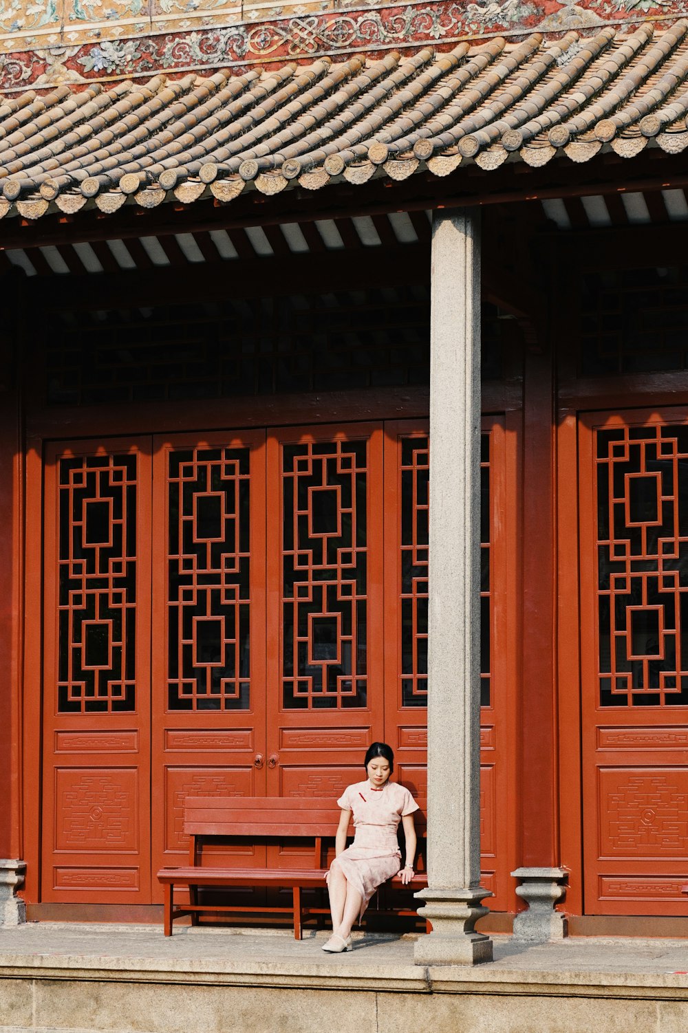 a woman sitting on a bench in front of a building