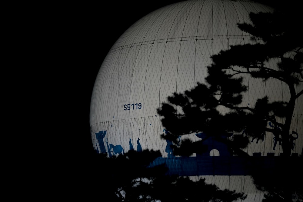 a large white object with a tree in front of it