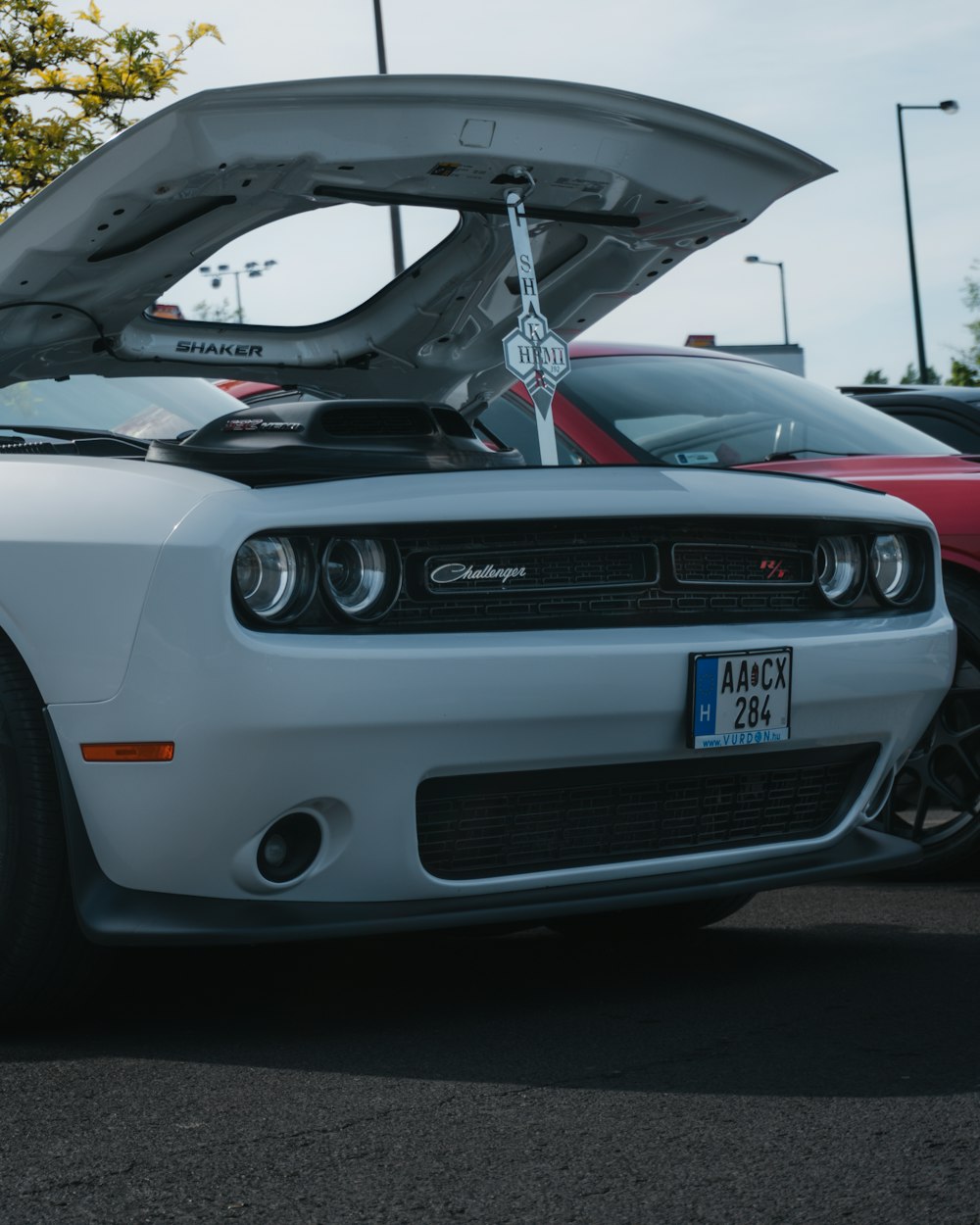 a white car with its hood open in a parking lot