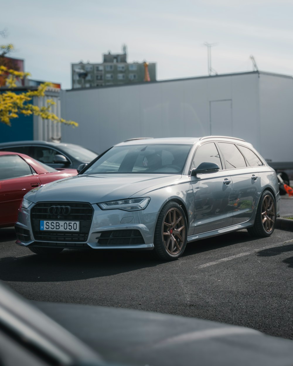 a silver car parked in a parking lot next to other cars