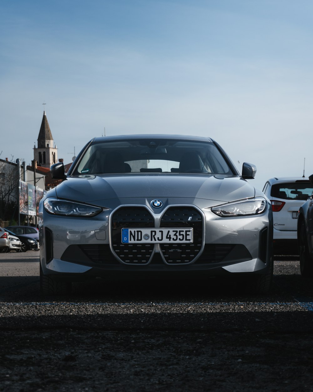 a silver car parked next to a white car