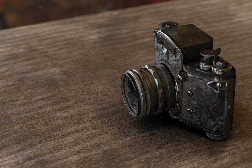 an old camera sitting on top of a wooden table