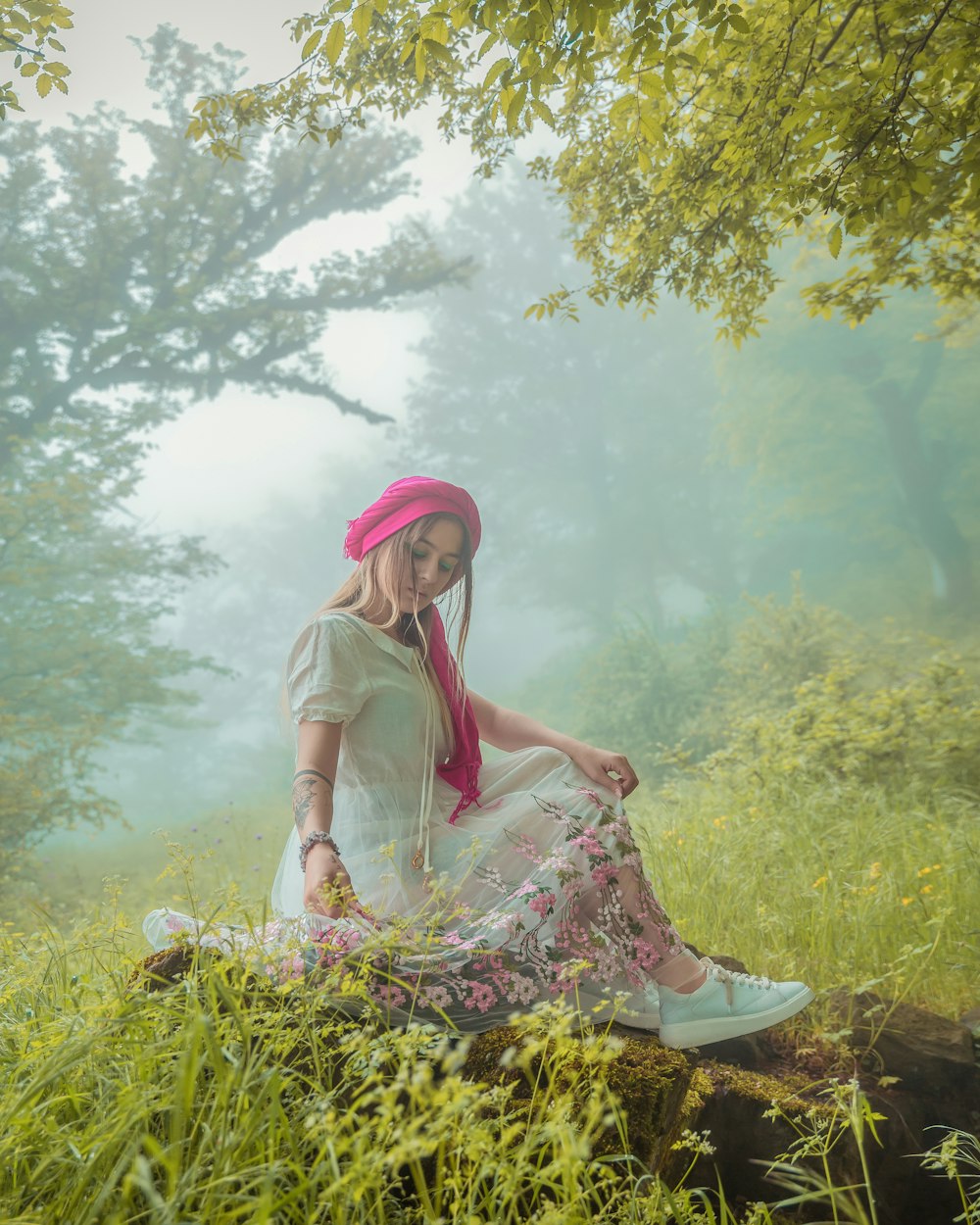 a woman sitting on a log in a field