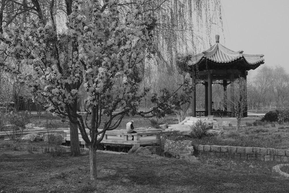 a black and white photo of a gazebo in a park