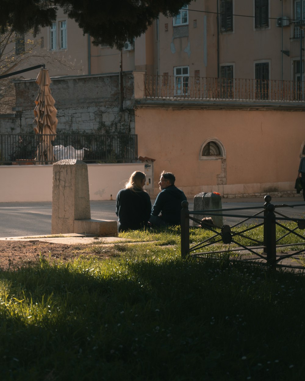 a couple of people sitting on top of a lush green field