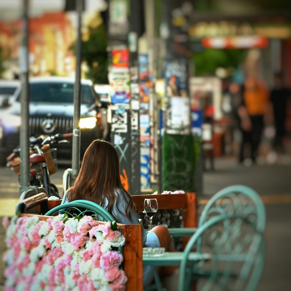 a woman sitting on a bench next to a sidewalk