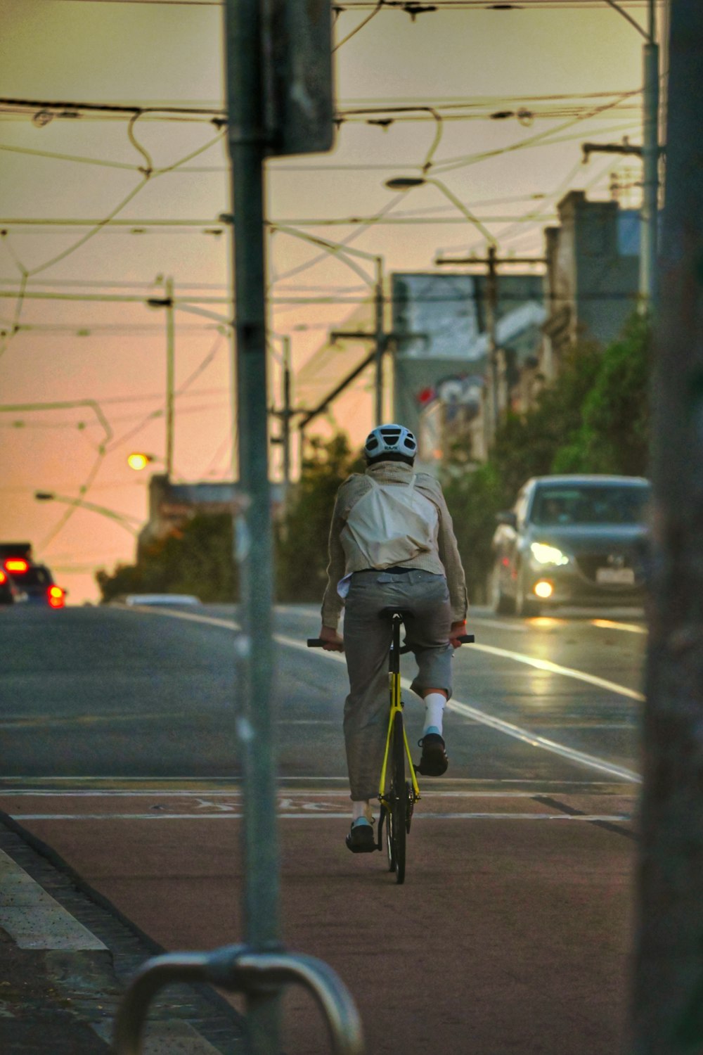 a man riding a bike down a street next to a traffic light