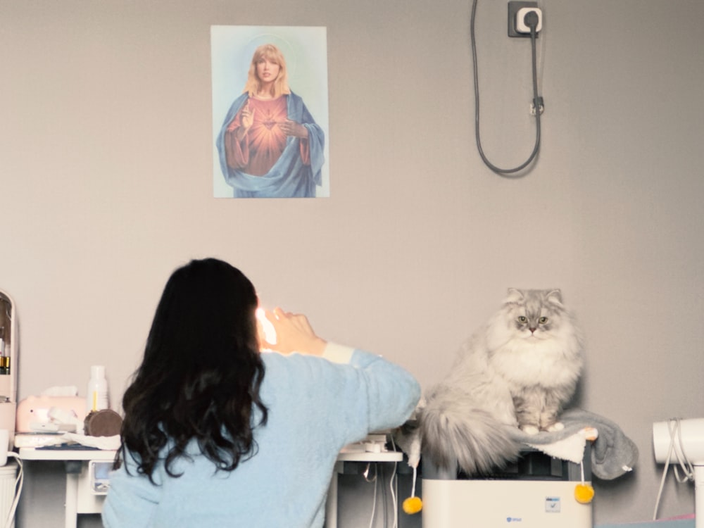 a woman taking a picture of a cat in a room