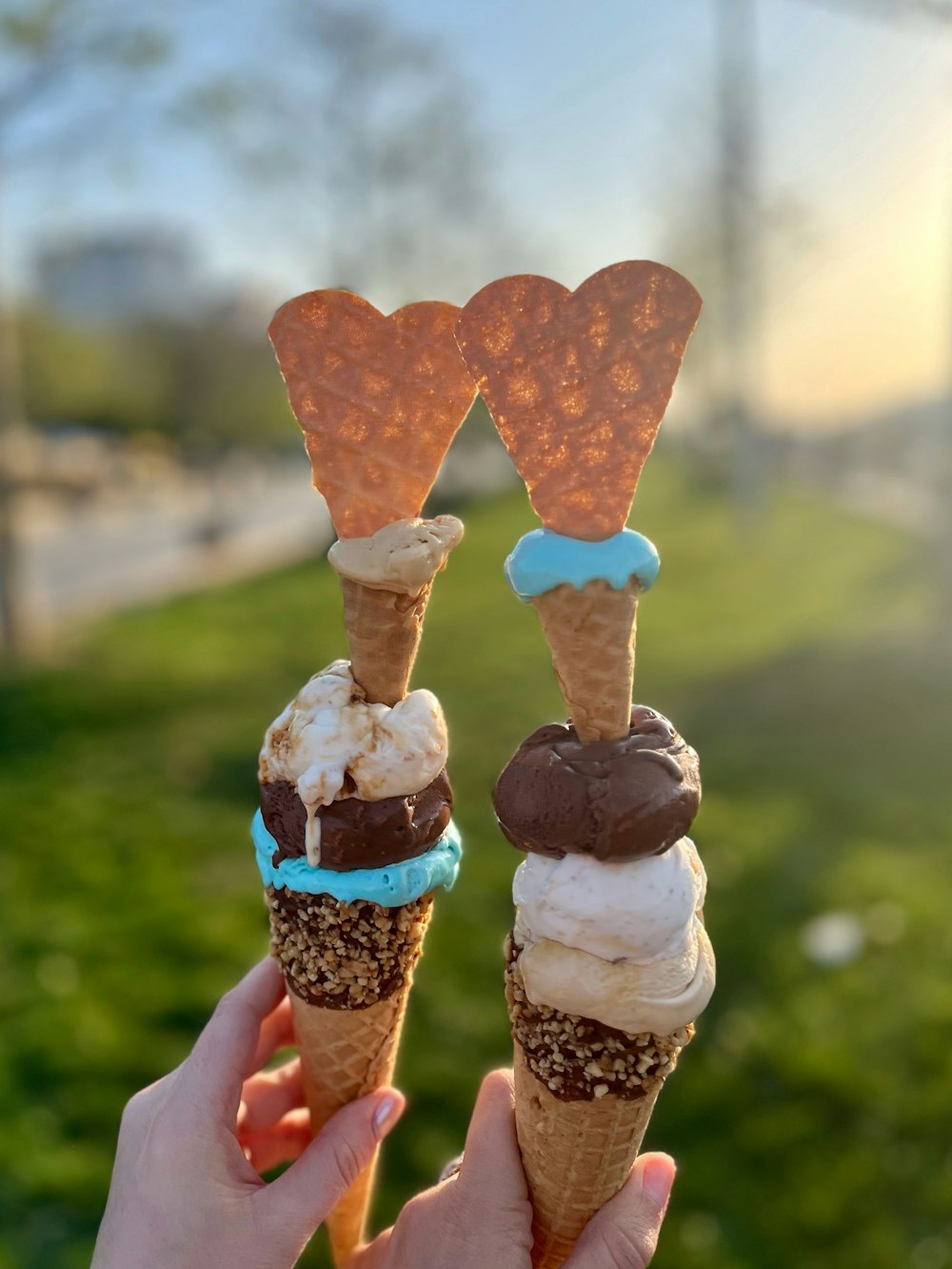 a person holding two ice cream cones in their hands