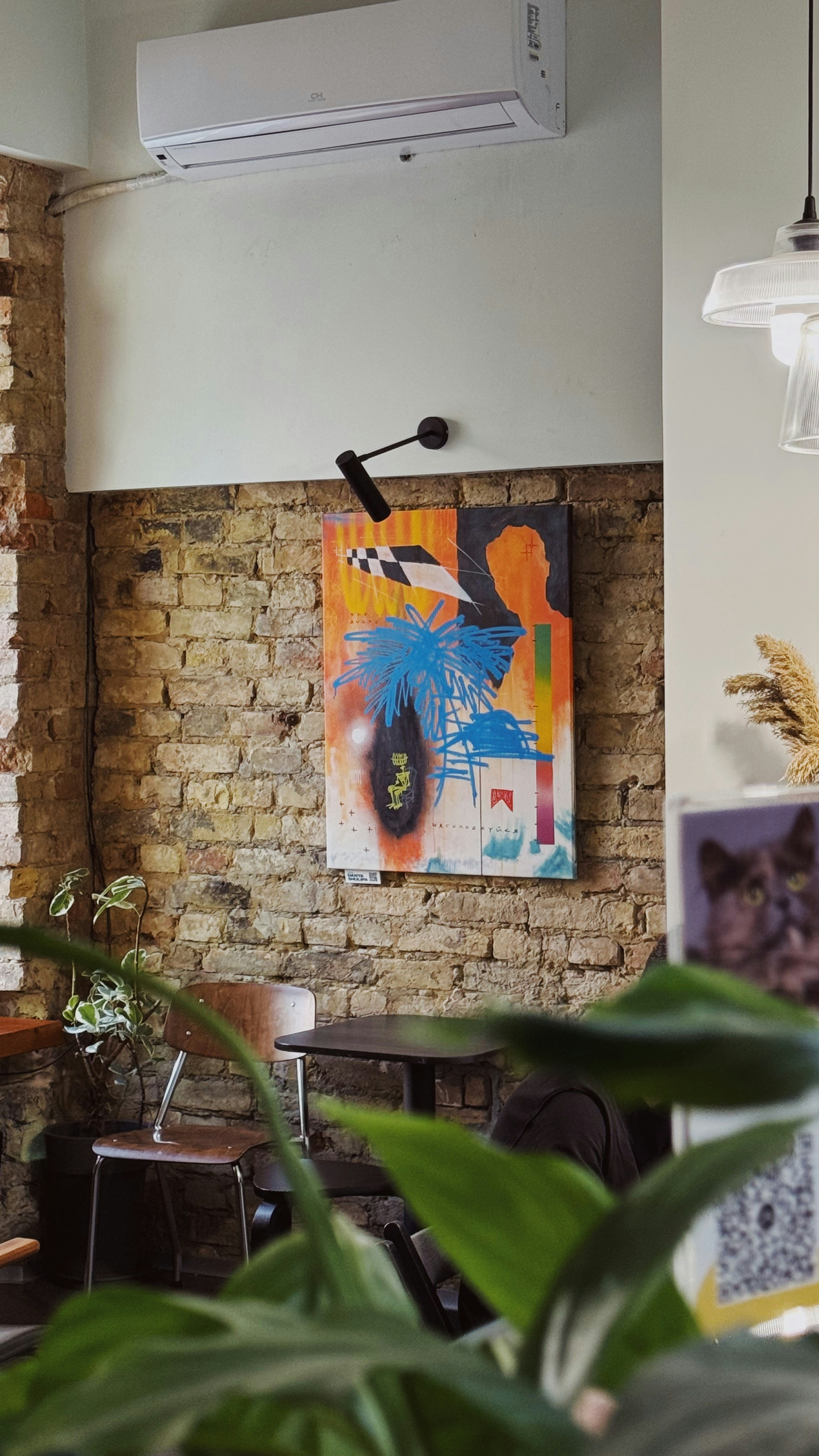 a room with a brick wall and a painting on the wall