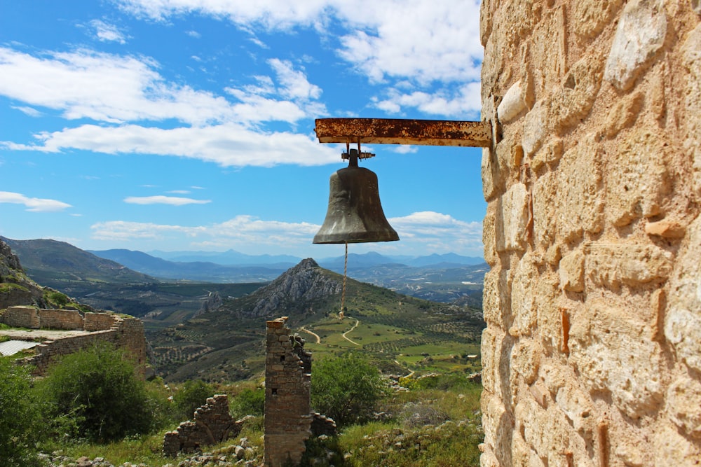 a bell hanging from the side of a stone building